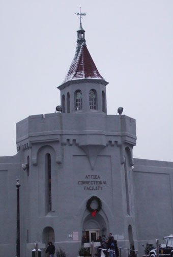 Gray high-walled prison building with turreted tower