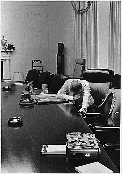 LBJ at his desk with head down
