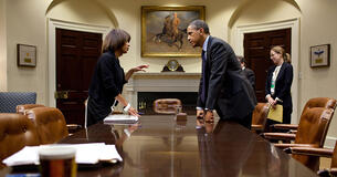 Melody Barnes and President Barack Obama talk over a table