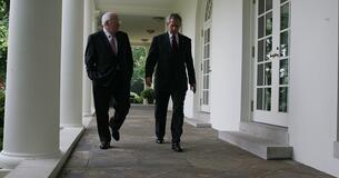 President George W. Bush and Vice President Cheney walk outside the White House.