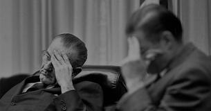 LBJ and McNamara with their heads in their hands looking tired