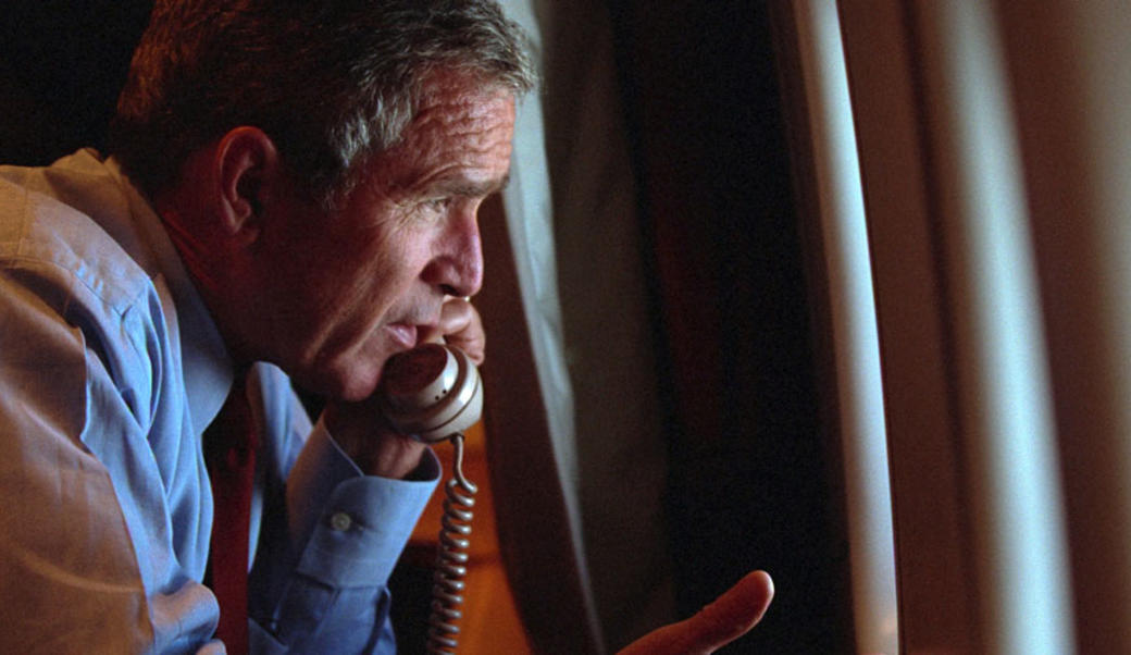 President George W. Bush on the telephone looking out a window
