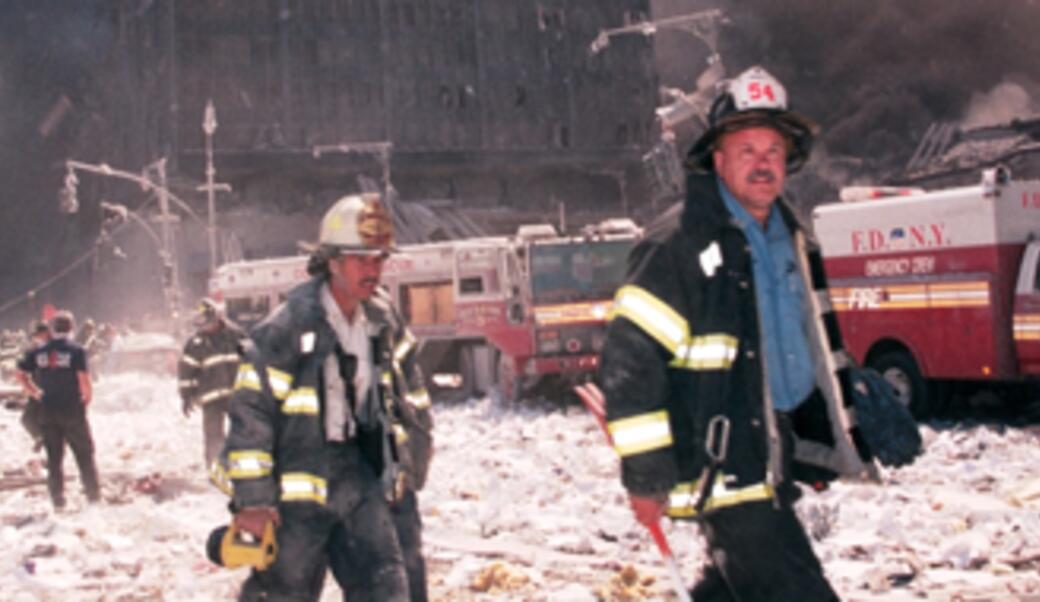 New York City firefighters walk near Ground Zero after the collapse of the Twin Towers on September 11, 2001.