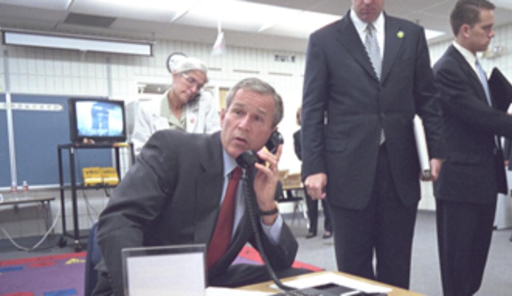 President George W. Bush talks on a secure phone at Emma E. Booker Elementary School in Sarasota, FL, on September 11, 2001.