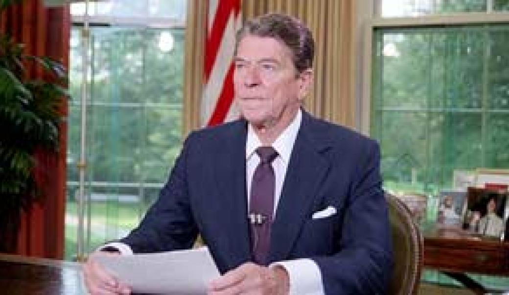 President Ronald Reagan sits at his desk