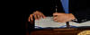 hand of Barack Obama signing bill